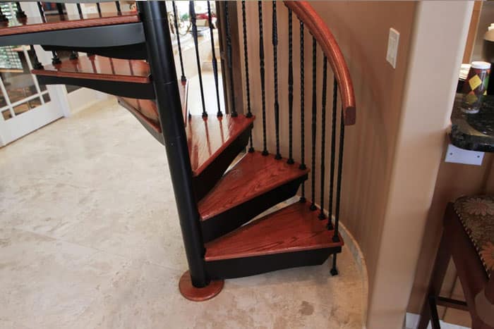 forged iron spiral stair with solid wood steps and handrail