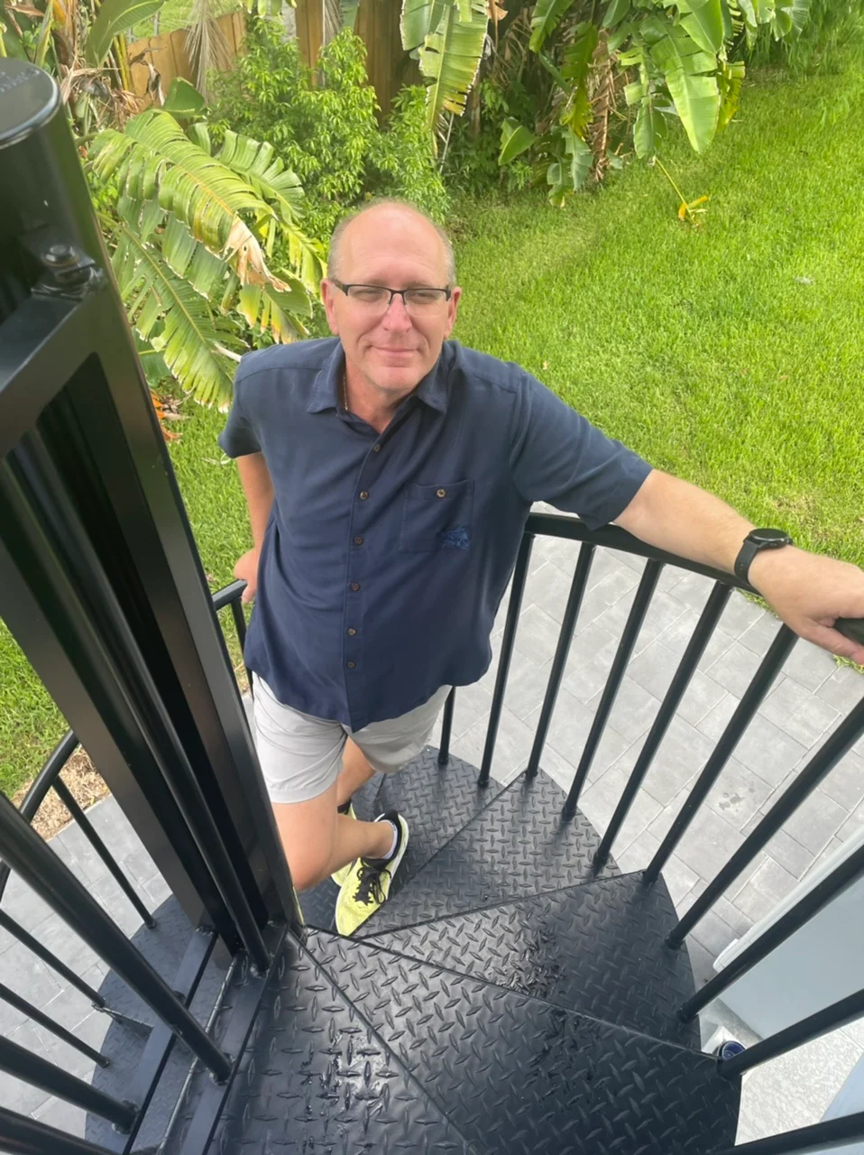 client standing on outdoor spiral staircase