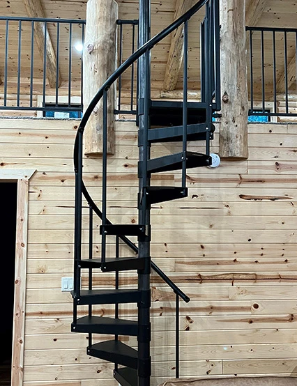 small space all black steel spiral stair in wood cabin to loft