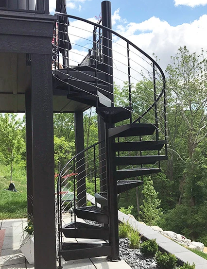 black spiral staircase with modern railing attached to a residential deck and connecting it to a lower patio