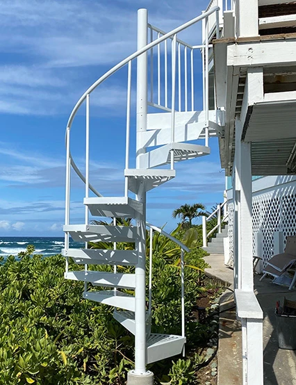 white powdercoated spiral stair to deck on side of beach house
