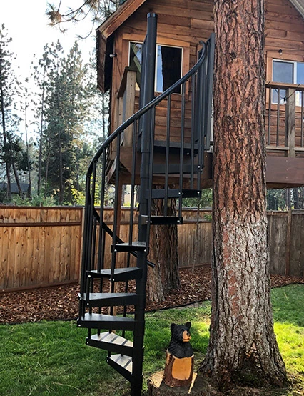 outdoor spiral stair going to treehouse in backyard