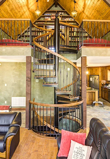 ornate multistory spiral staircase in a rustic home that connected multiple levels of the house, including the basement and loft