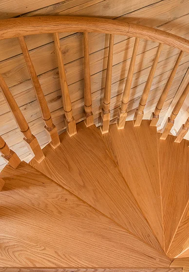 solid wood spiral staircase in a wood paneled cabin