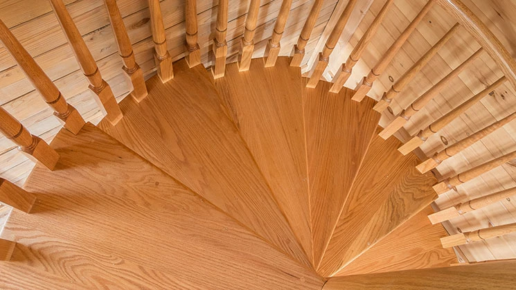 solid wood spiral staircase in a wood paneled cabin
