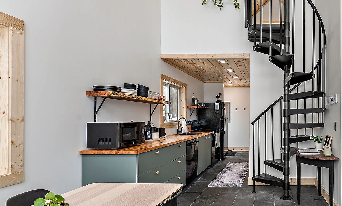 steel spiral staircase with easy installation in tiny house cabin leading to sleeping loft