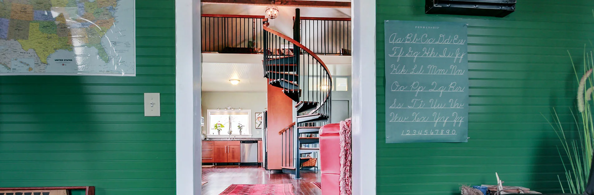 Modern spiral staircase in a light-filled modular home, showcasing open design and a compact footprint.